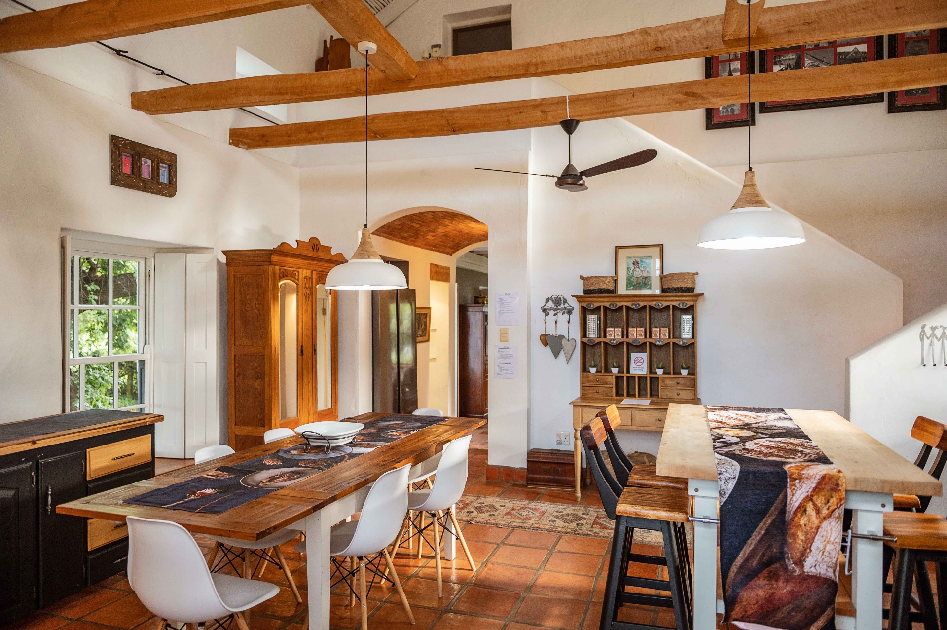 Open-plan dining and kitchen with exposed beams and pendant lights