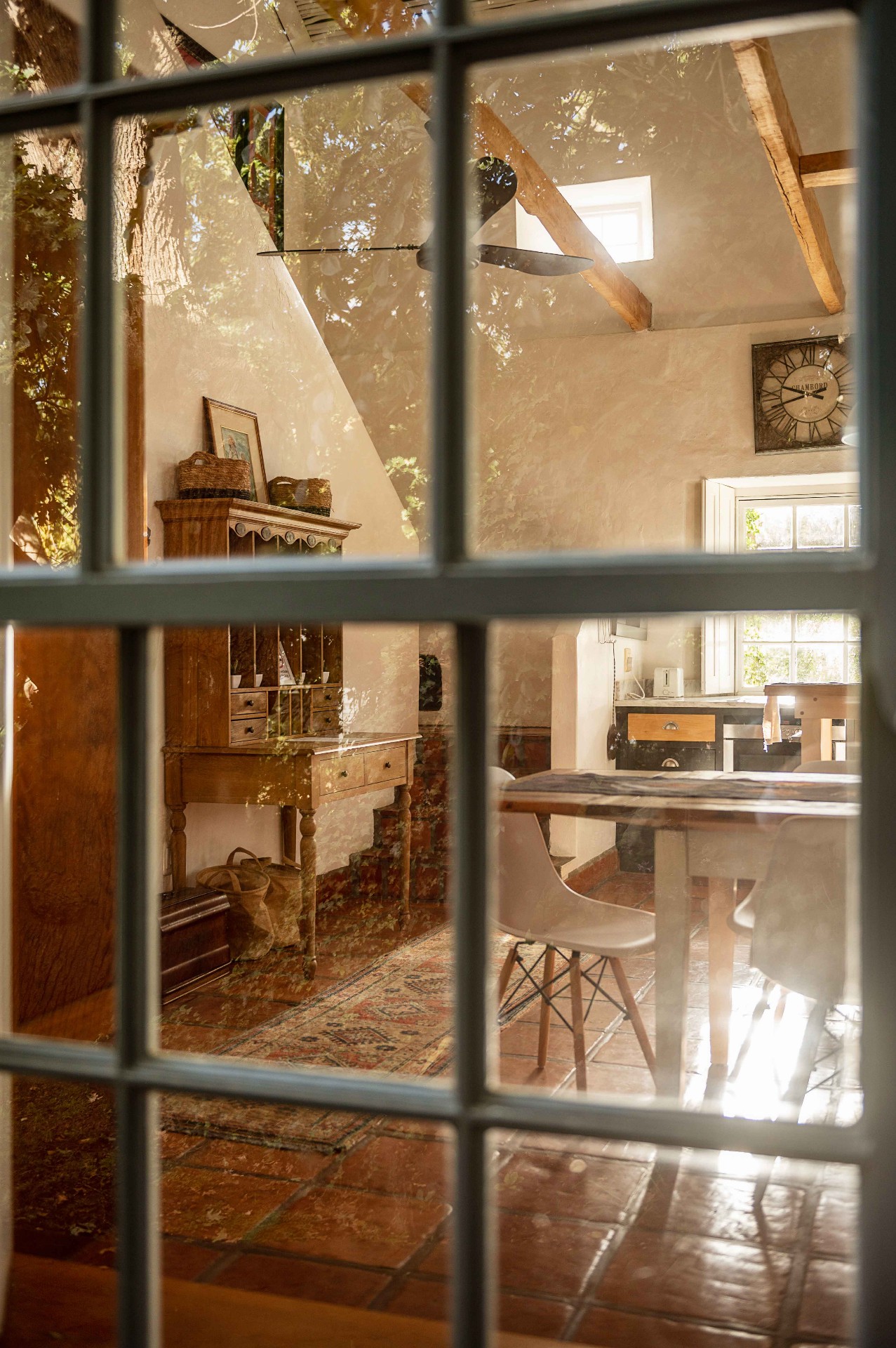View through the cottage window into the timber-beamed kitchen