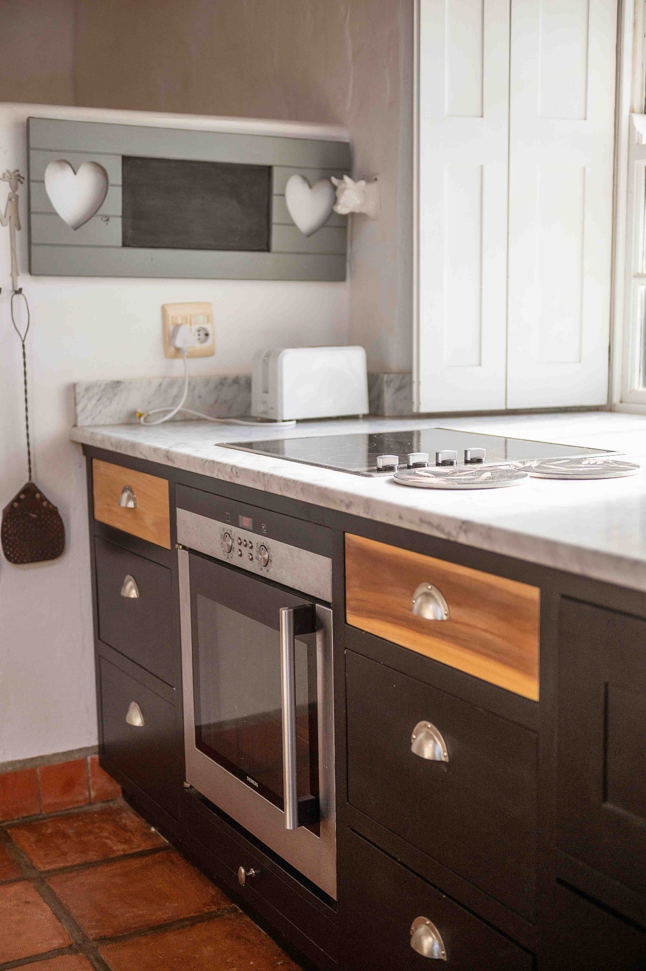 Country kitchen with marble countertop, oven and timber drawers