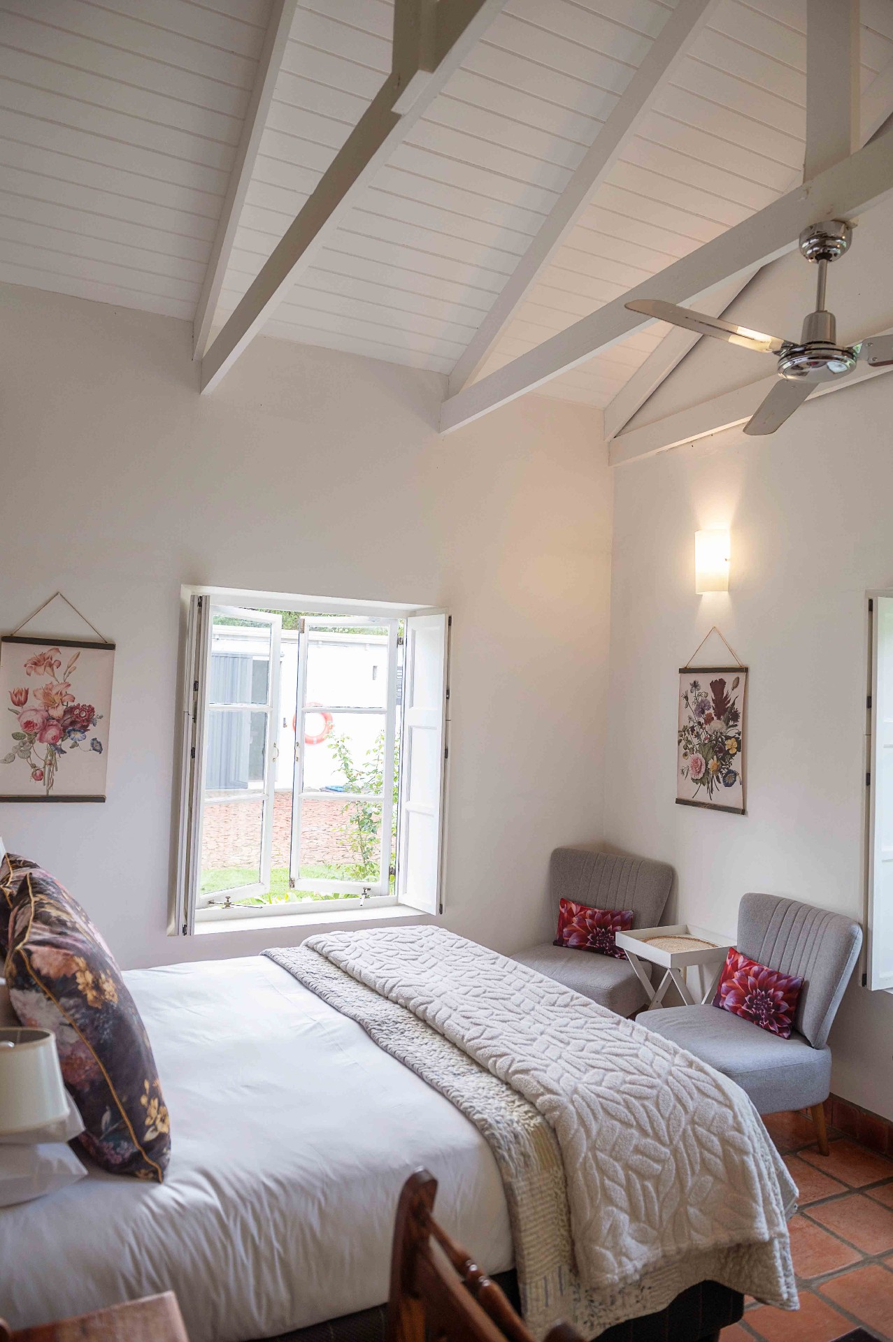 Bedroom with vaulted beamed ceiling and open garden window