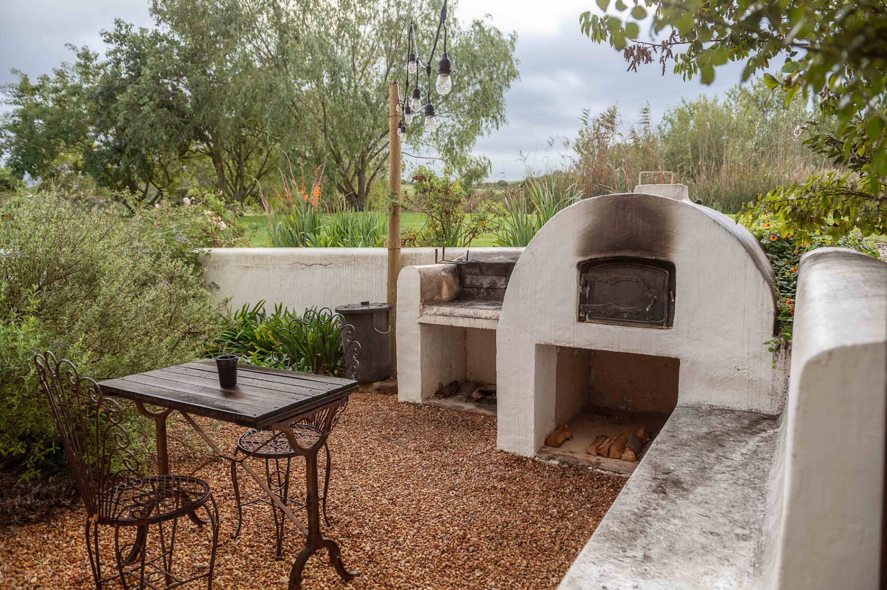 Outdoor wood-fired oven and patio with garden views