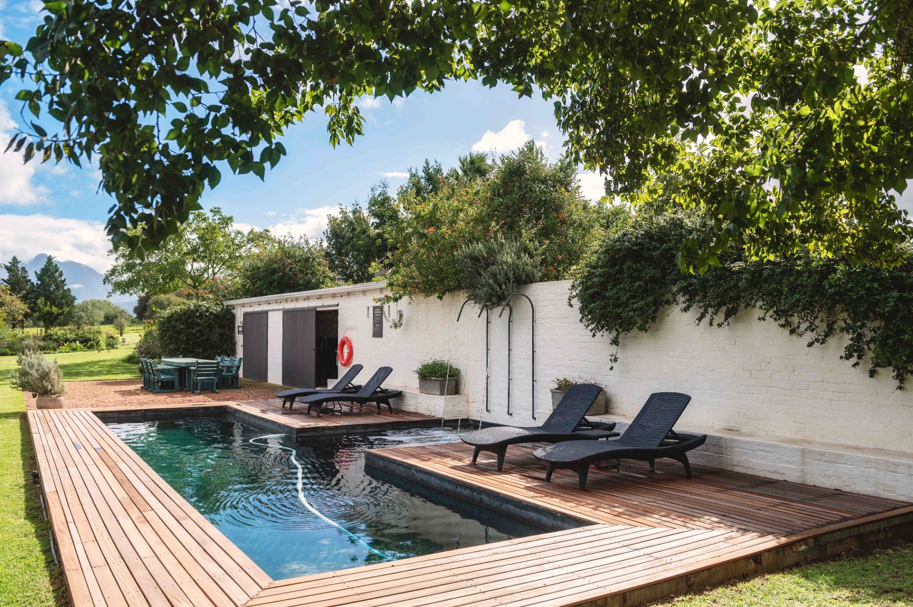 Swimming pool with wooden deck and mountain backdrop
