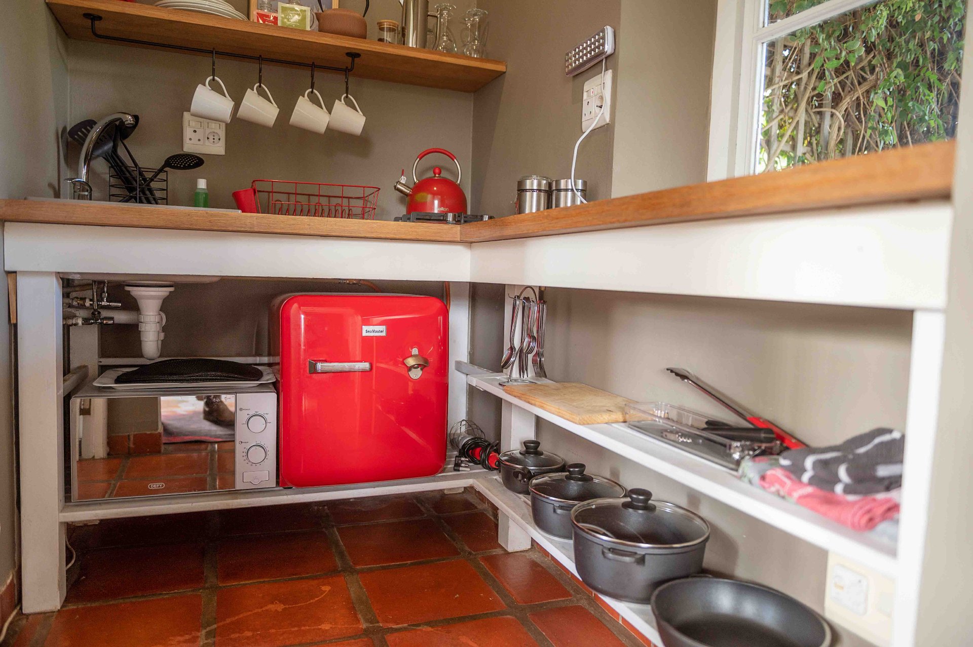 Shared kitchen with retro red bar fridge and cookware