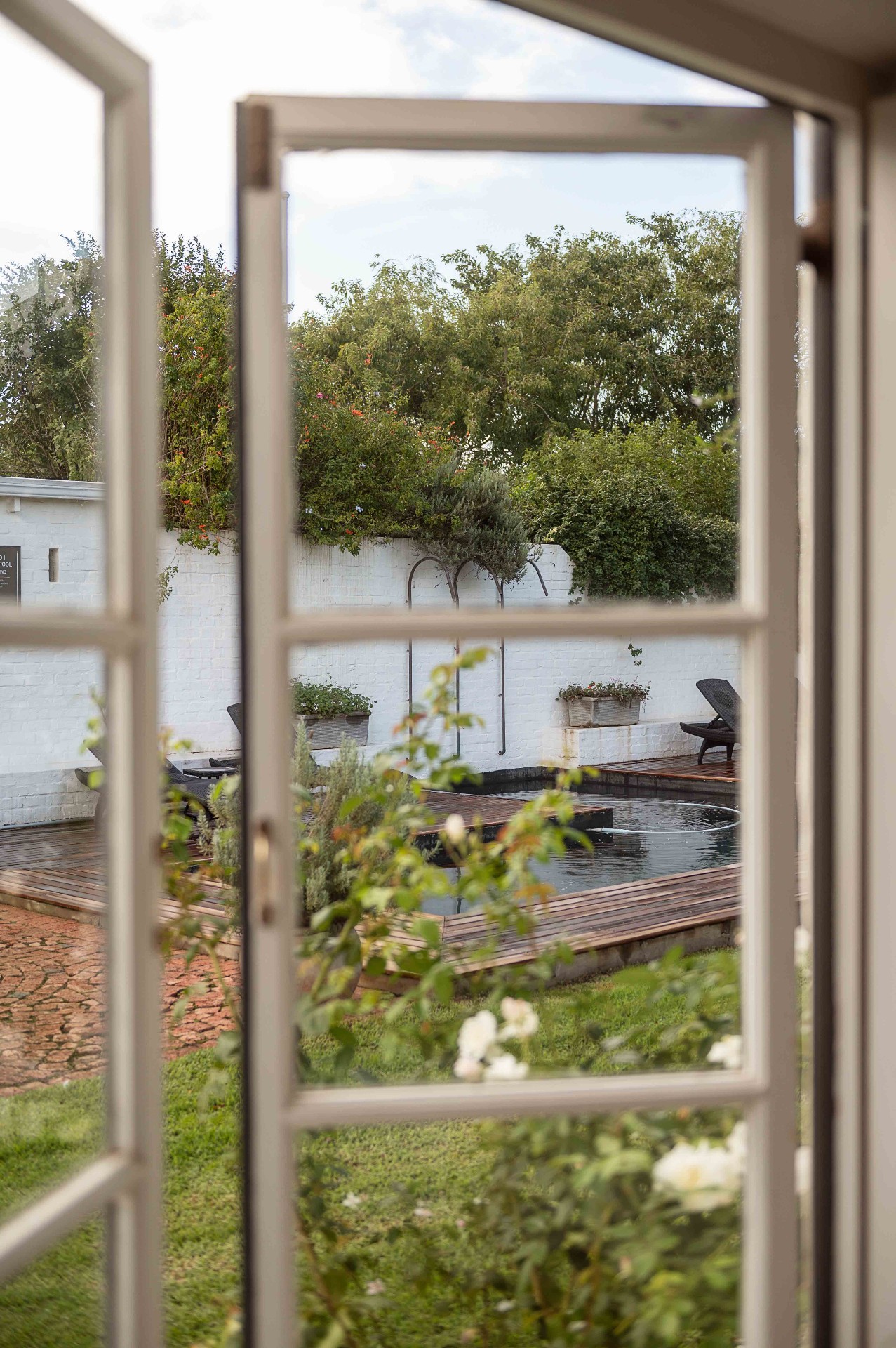 View through cottage doors onto the pool and garden
