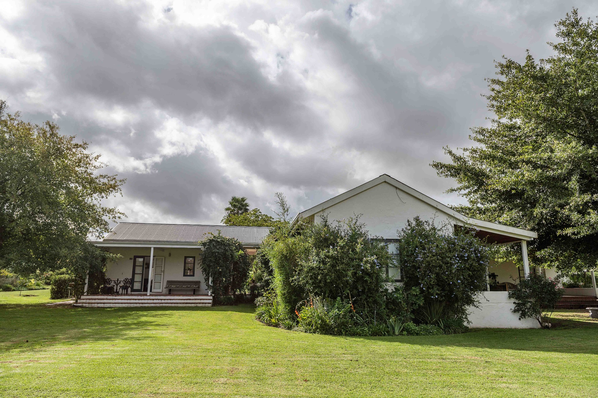 Guest house exterior with sweeping lawn and dramatic sky
