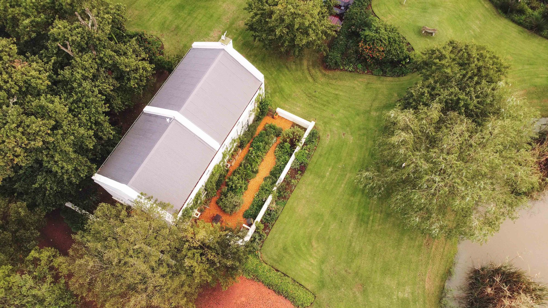 Top-down aerial view of cottage rooftop and herb garden