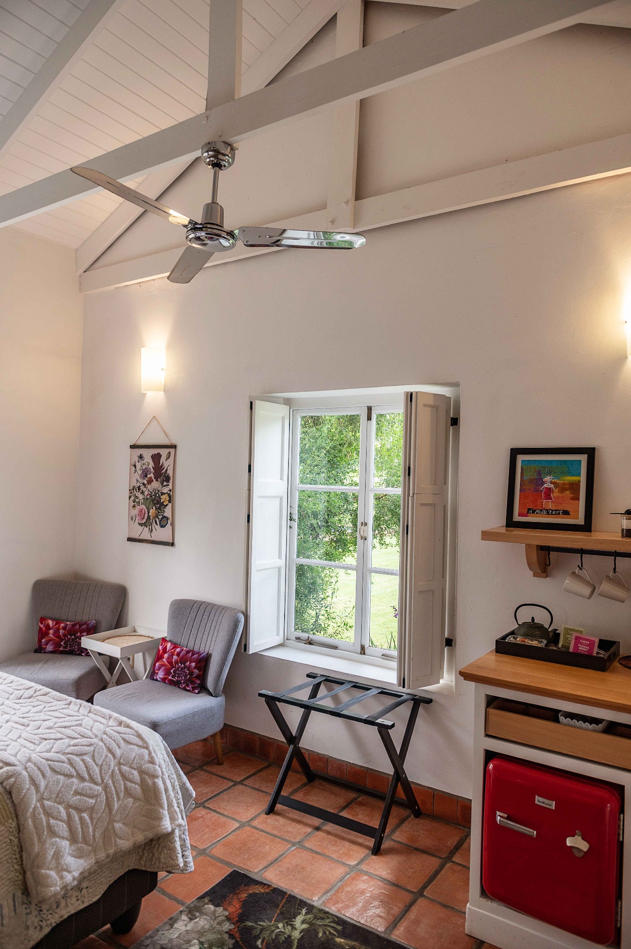 Bedroom with vaulted ceiling, ceiling fan and shuttered window