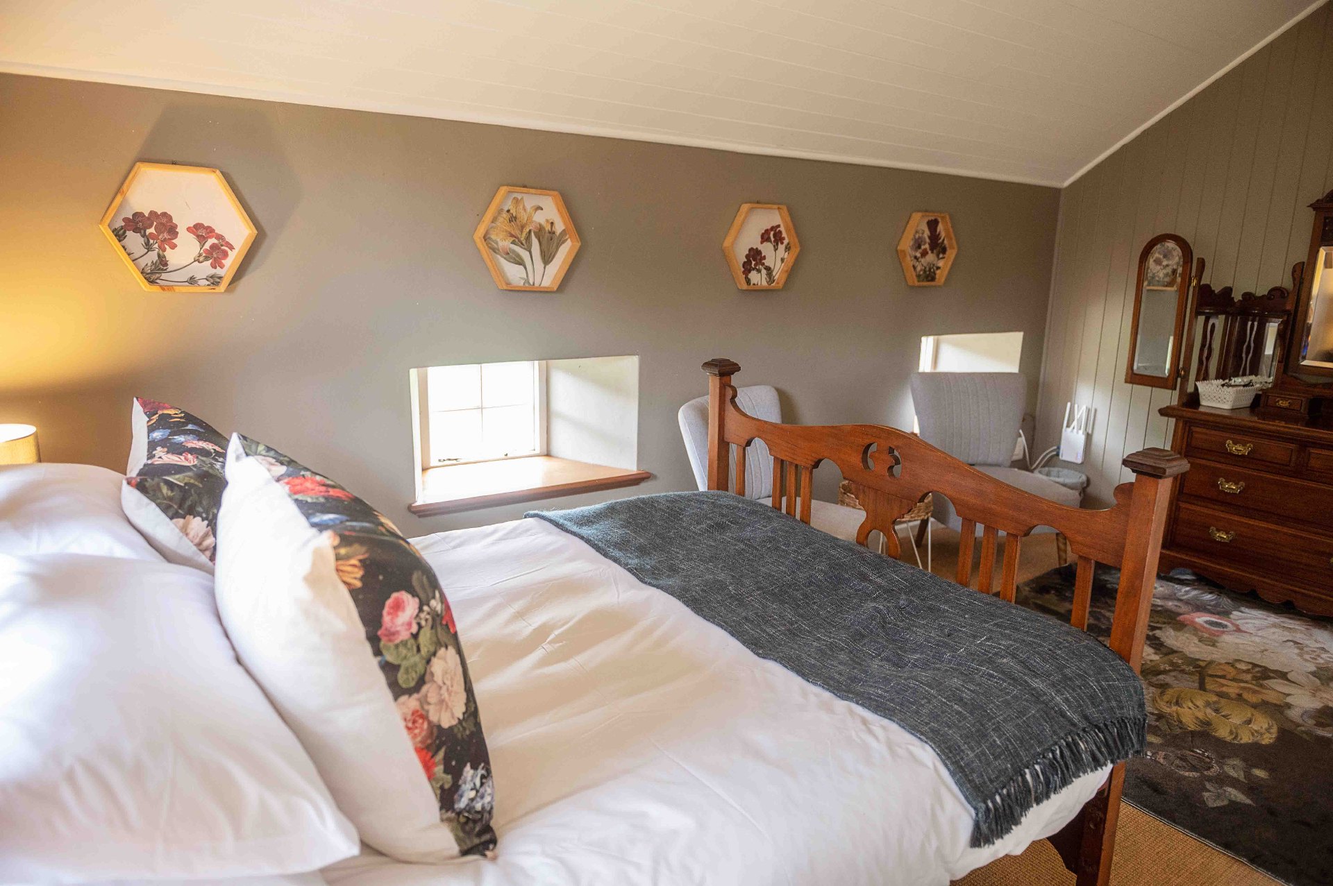 Bedroom with floral pillows and botanical wall art
